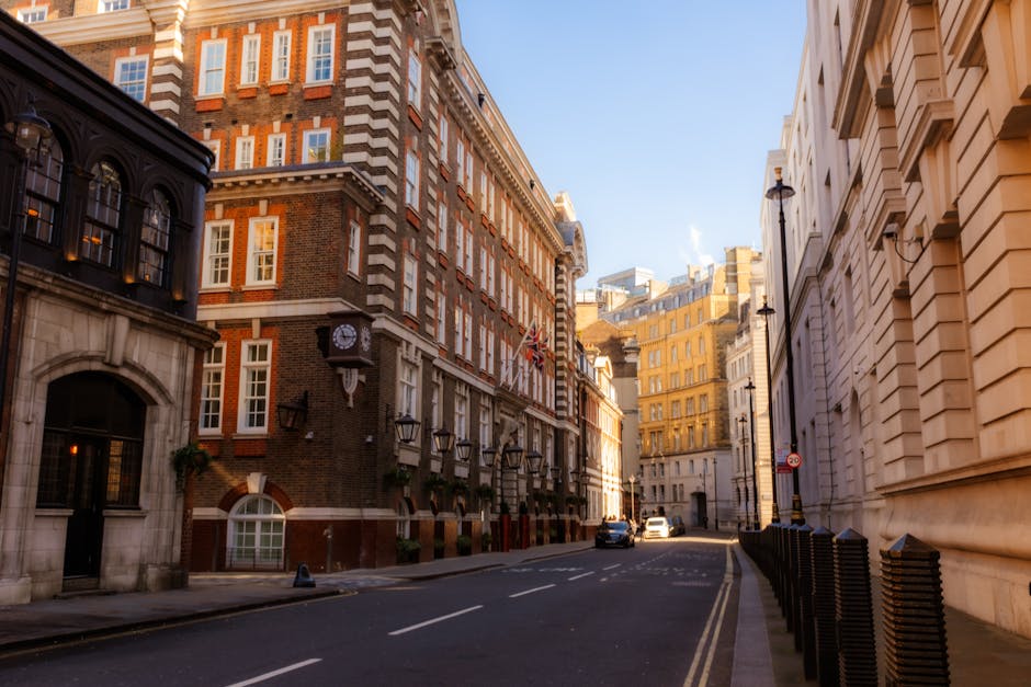 Exterior view of a row of elegant Westminster period buildings featuring brick and white-painted facades, tall sash windows, decorative wrought iron balconies with potted plants, and a classic street